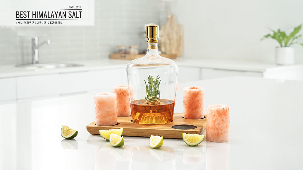 Himalayan salt shot glasses displayed with pink Himalayan salt products on a wooden serving tray in a modern kitchen
